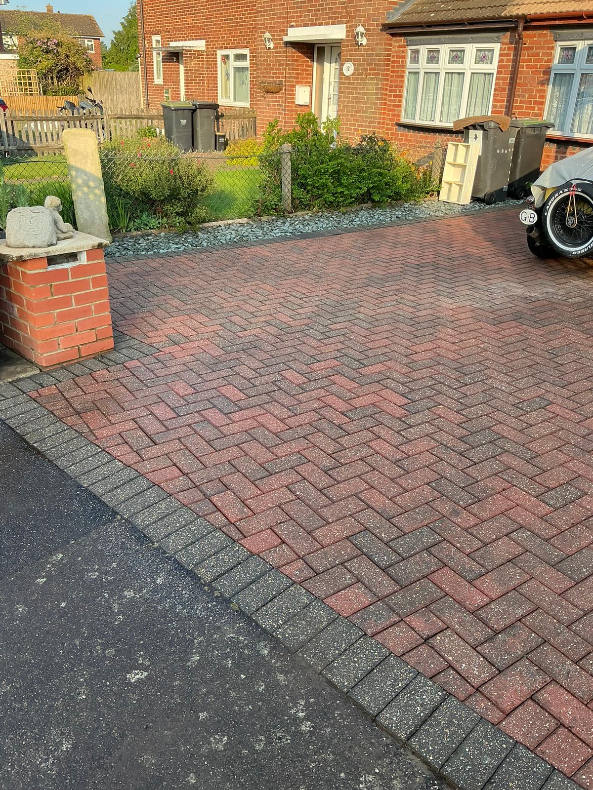 Red herringbone block paving driveway restored and vibrant after professional pressure washing