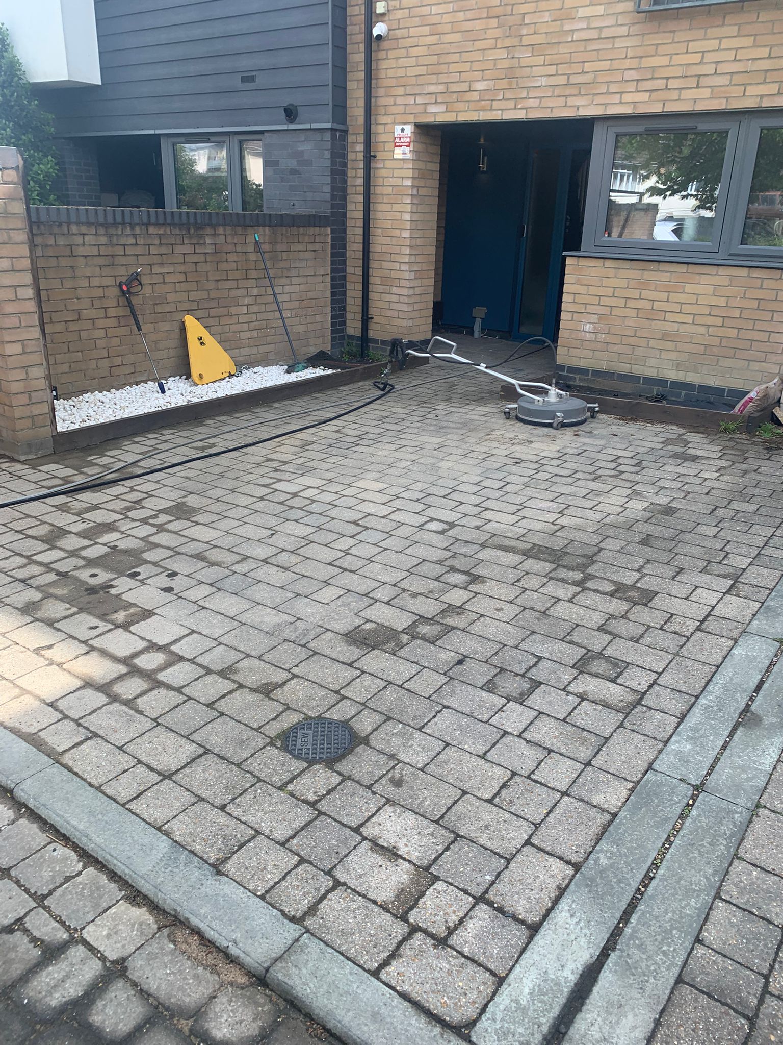 Commercial block paving courtyard covered in dirt and algae before professional pressure washing in Kent